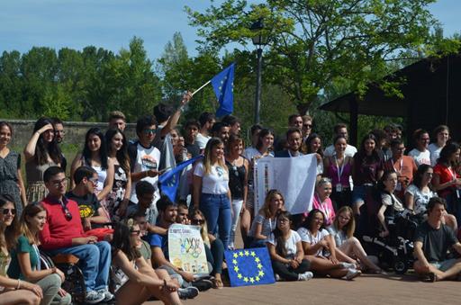 La directora de Juventud de Castilla y León posa con los asistentes al International Summer Festival rodeada de banderas europeas