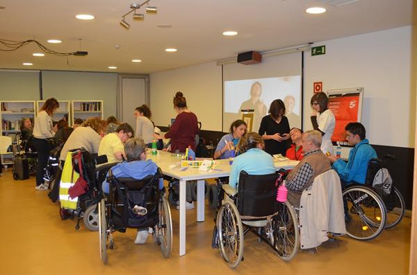 Voluntarios prestando su ayuda en los talleres de la residencia ASPAYM