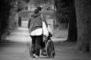 Foto de una mujer con una persona en silla de ruedas