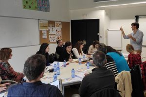 Fotografía de los asistentes a la reunión en una mesa atendiendo a una explicación del coordinador