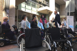 alcalde de león y representantes de aspaym posan junto a sillas de ruedas