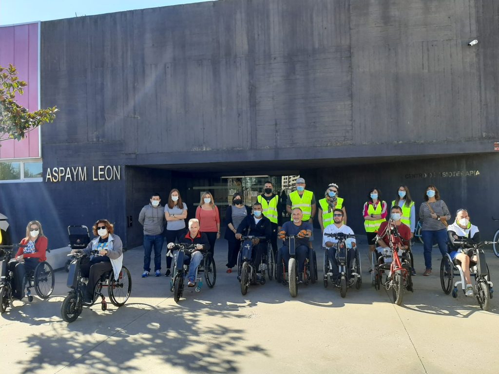 Usuarios posan con las handbikes en la entrada de la sede de León antes del inicio de la ruta