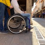Asistente Personal hace turismo con persona en silla de ruedas por un pueblo de la comunidad