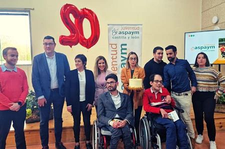 Representantes institucionales posan con una tarta por los 20 años de ASPAYM CYL Juventud