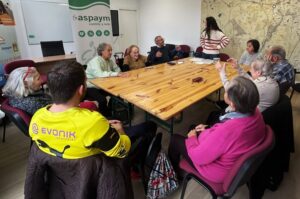 Participantes de la tercera sesión de ASPAYM Mayores en Sahagún realizan la actividad alrededor de la mesa