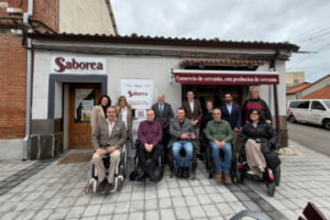 Asistentes a la entrega del premio CERMI a Saborea Castilla y León posan en la entrada de la tienda